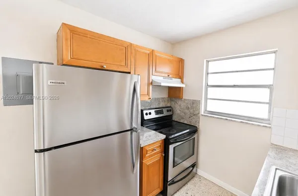 a white refrigerator freezer and a stove sitting inside of a kitchen