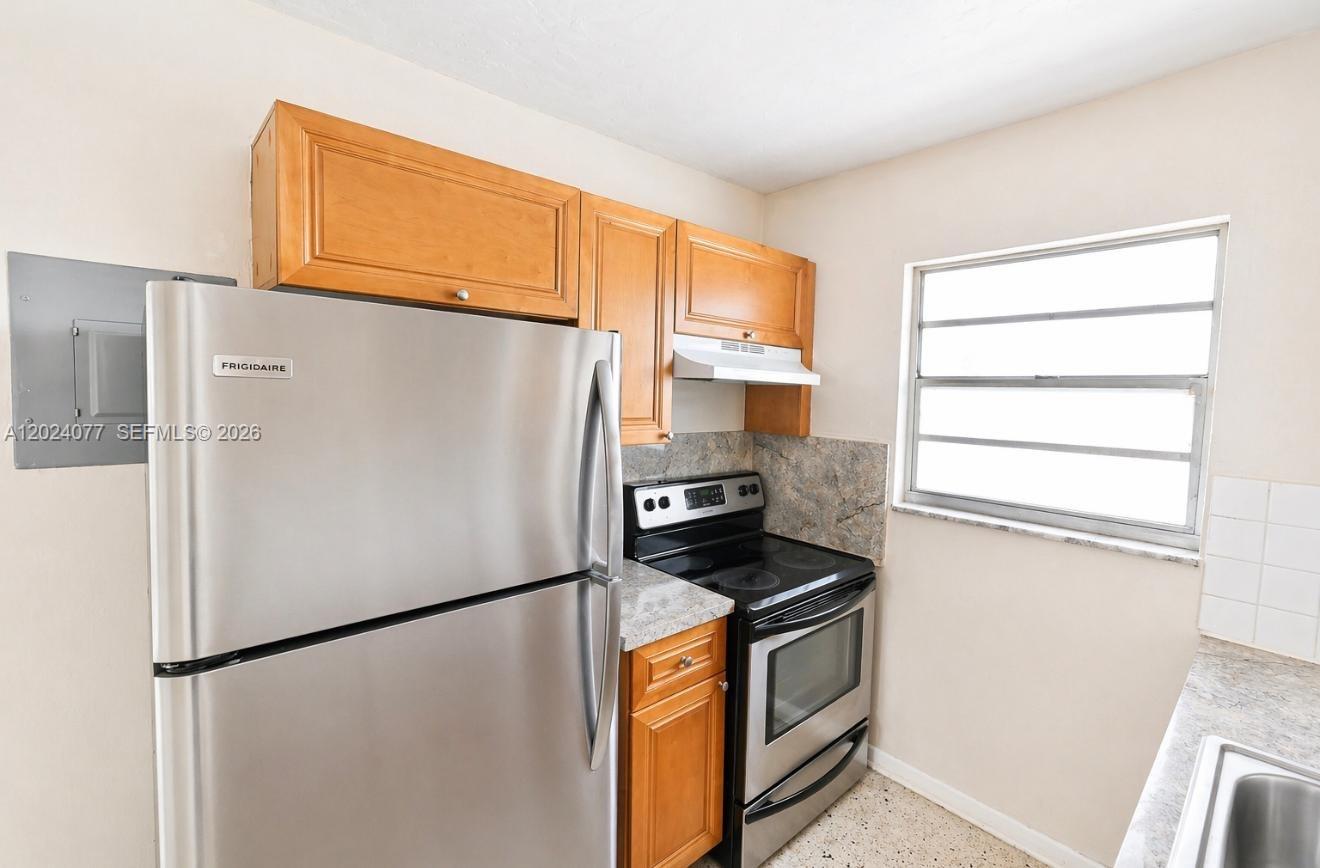 2315 West Okeechobee Road, Unit 304 Hialeah, FL 33010 - Photo 1 of 8 a white refrigerator freezer and a stove sitting inside of a kitchen