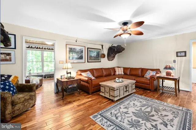 a bedroom with a bed and dresser with wooden floor