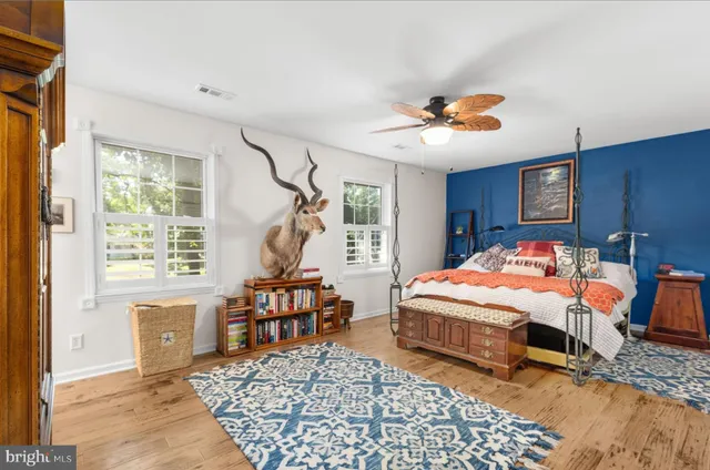 a bedroom with a bed a dresser and chair