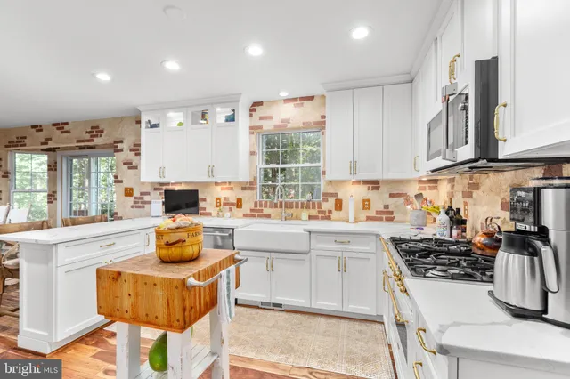 a kitchen with stainless steel appliances kitchen island granite countertop a sink and cabinets