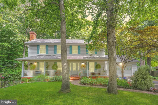 a front view of a house with a yard and trees