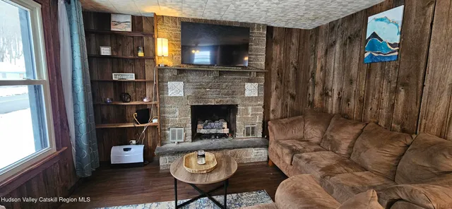 a living room with furniture a fireplace and a window