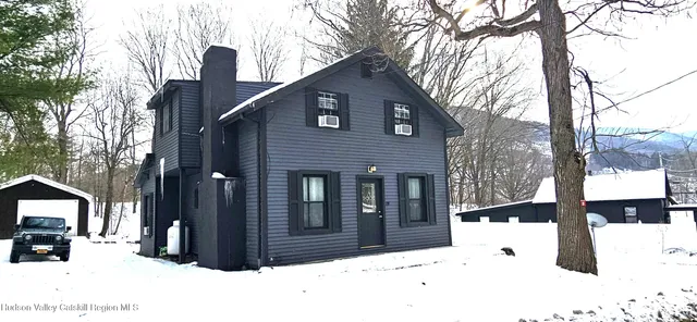 a view of a house with a yard covered in snow