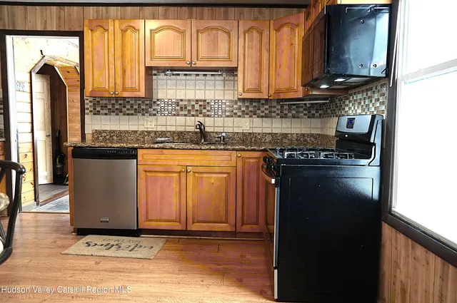 a kitchen with stainless steel appliances granite countertop a stove a sink and a microwave