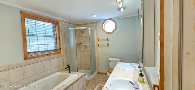 a bathroom with a sink a toilet and shower