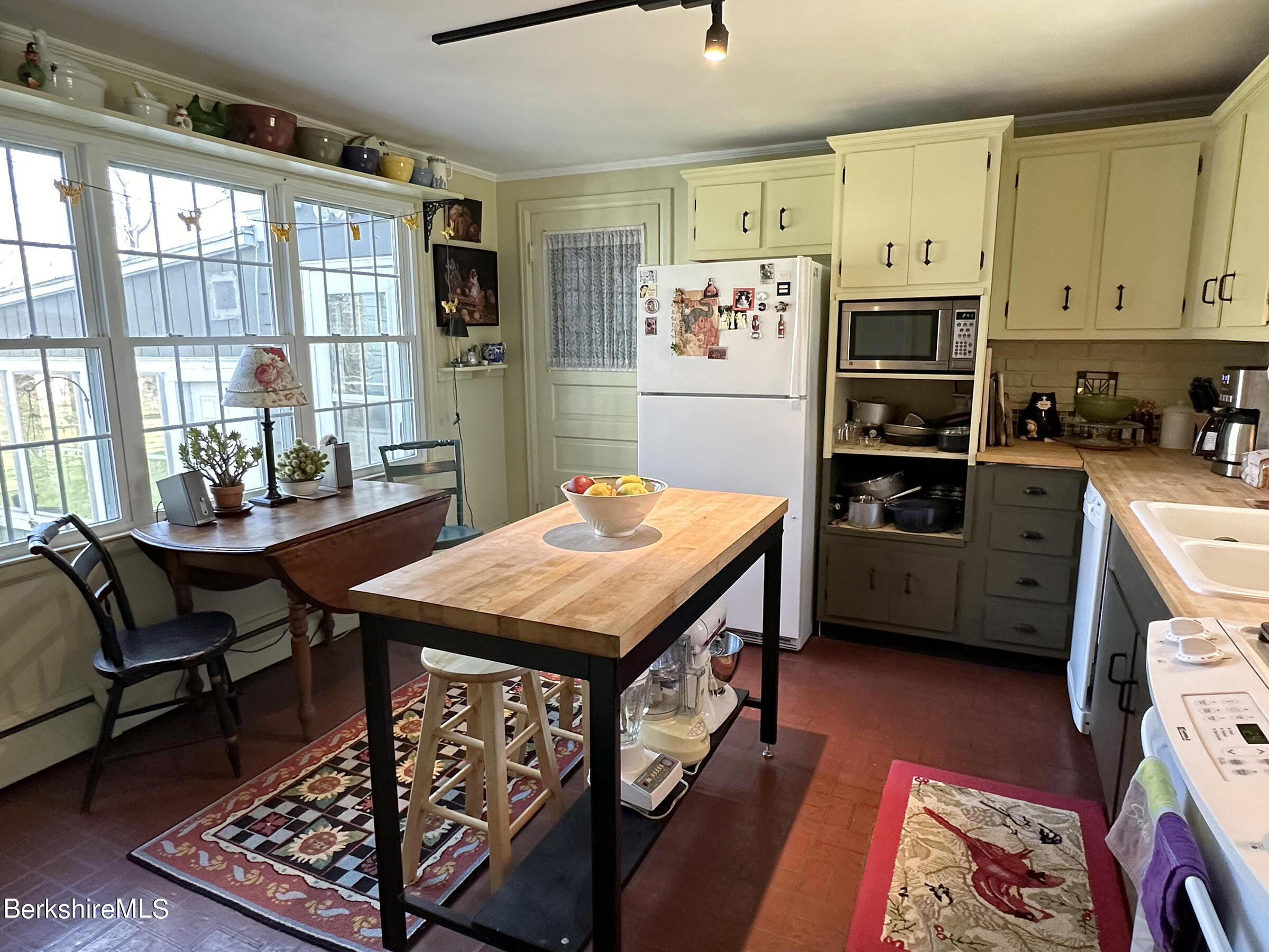 224 County Rte 7A Copake, NY 12516 - Photo 7 of 14 a kitchen with stainless steel appliances granite countertop a stove a refrigerator a kitchen island a dining table and chairs with the wooden floor