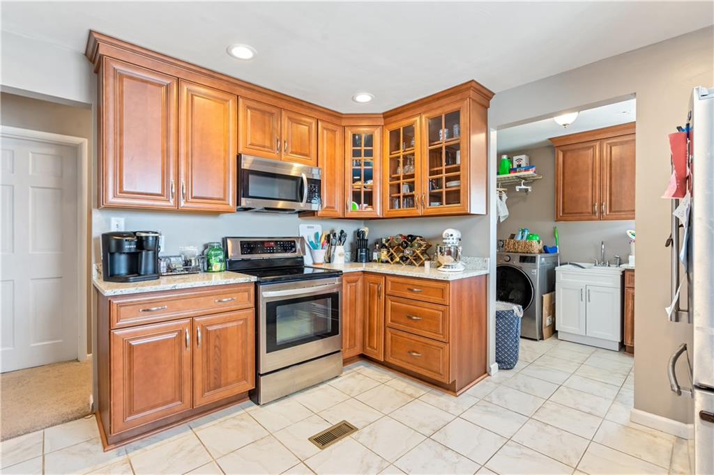 414 Hancock Avenue Vandergrift, PA 15690 - Photo 15 of 25 a kitchen with stainless steel appliances granite countertop a stove top oven a sink a dining table and chairs with wooden floor