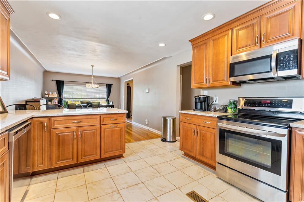 414 Hancock Avenue Vandergrift, PA 15690 - Photo 17 of 25 a kitchen with stainless steel appliances granite countertop a stove top oven a sink dishwasher and cabinets with wooden floor
