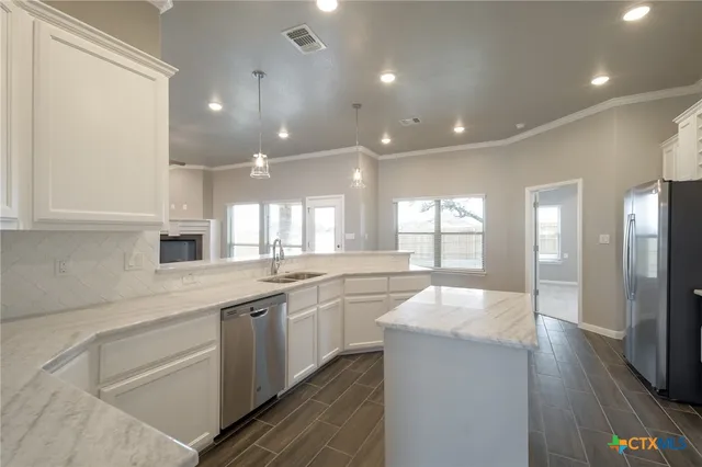 a large kitchen with kitchen island a sink stainless steel appliances and cabinets