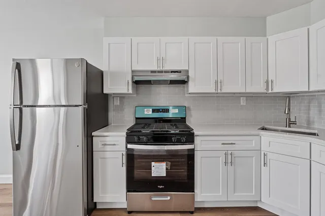 a kitchen with white cabinets and stainless steel appliances