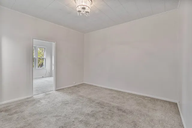 an empty room with a chandelier fan