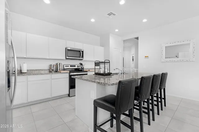 a kitchen with a dining table chairs and a refrigerator
