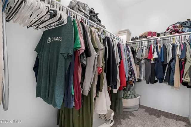 a view of walk in closet with clothes
