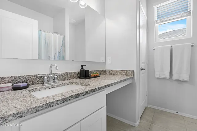 a bathroom with a granite countertop sink and a mirror
