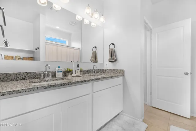 a bathroom with a sink vanity granite and a mirror