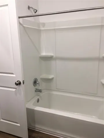 a bathroom with a shower and a bath tub