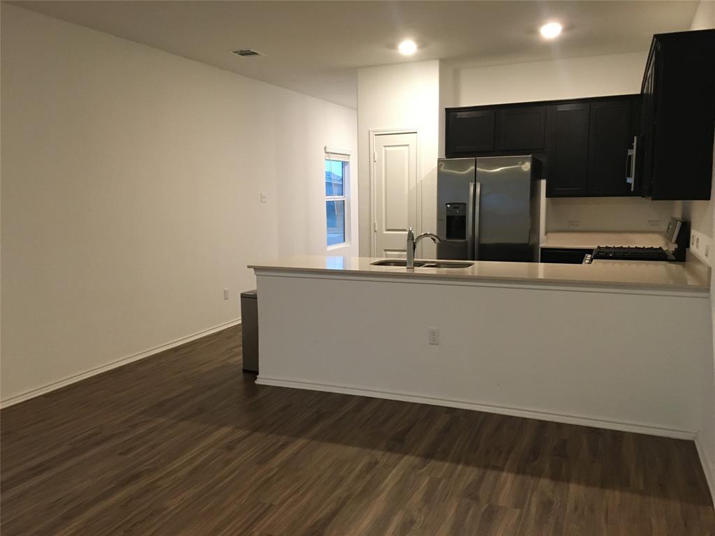 558 Gabbro Gardens Maxwell, TX 78656 - Photo 3 of 29 a view of a kitchen with wooden floor and electronic appliances