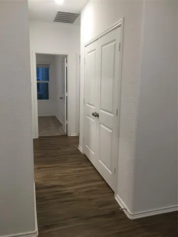 a view of a hallway with wooden floor
