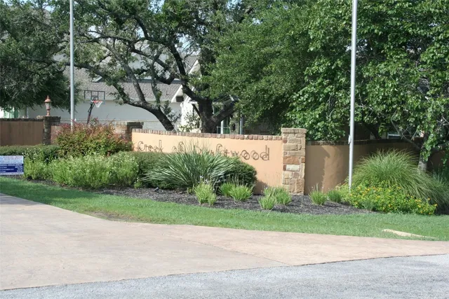 a backyard of a house with plants and large trees