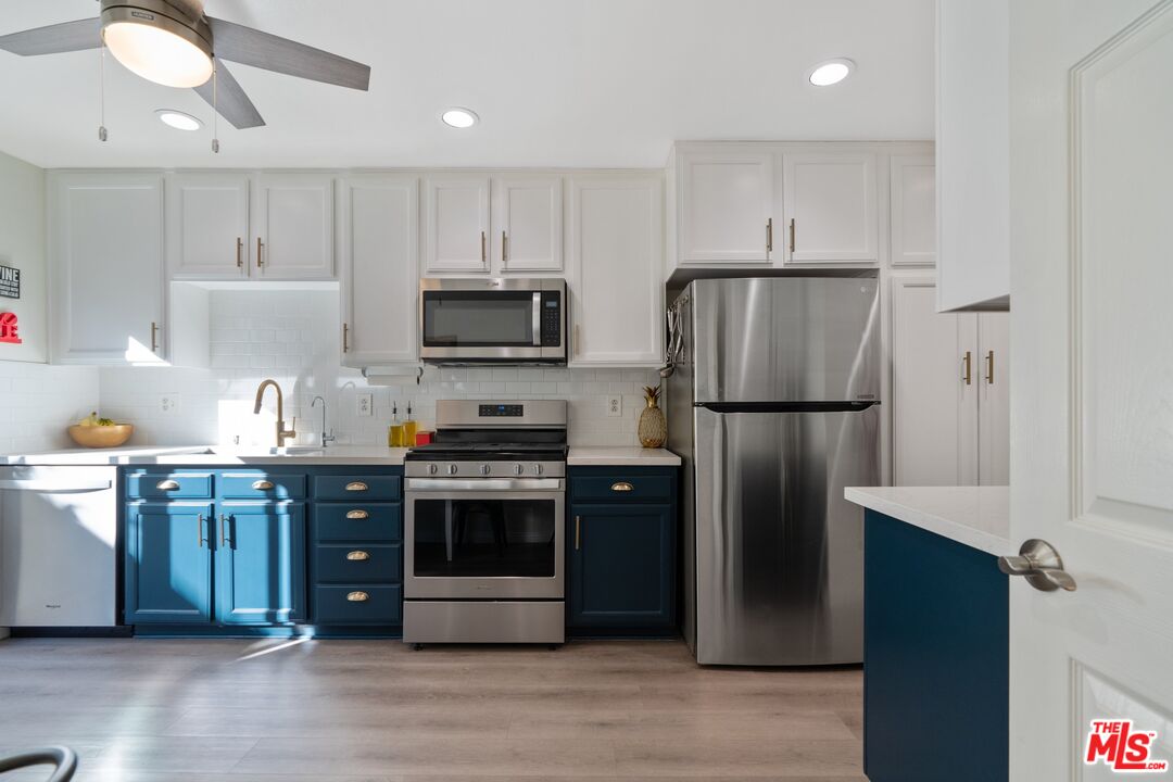 17221 Roscoe Boulevard, Unit 11 Northridge, CA 91325 - Photo 13 of 38 a kitchen with stainless steel appliances granite countertop a refrigerator stove a sink and a oven with wooden floor