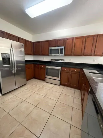a kitchen with stainless steel appliances granite countertop a sink a stove a microwave and cabinets