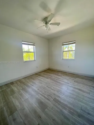 an empty room with a window and wooden floor