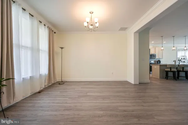 a view of a hallway with wooden floor table and windows