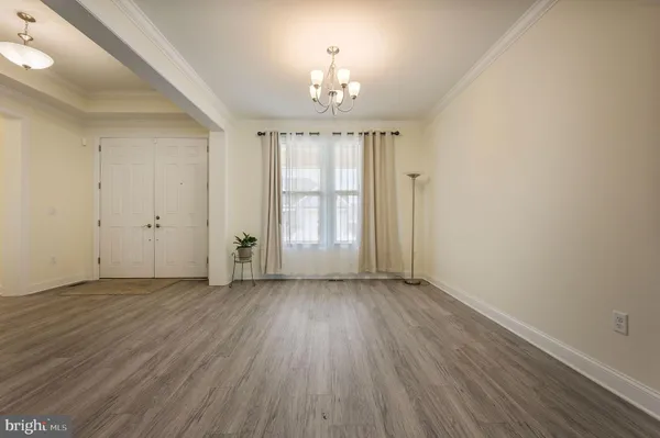 a view of a livingroom with furniture an entryway and chandelier