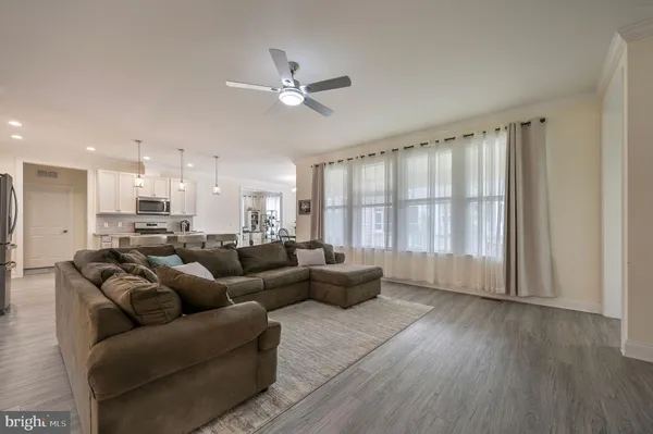 an empty room with wooden floor chandelier and windows