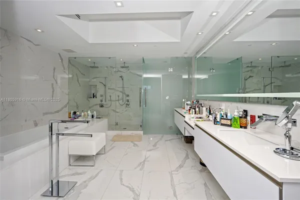 a bathroom with a sink mirror and shower