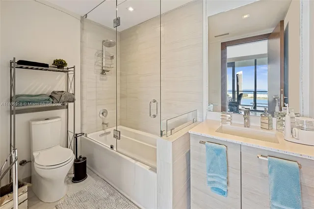 a bathroom with a granite countertop sink mirror vanity and toilet