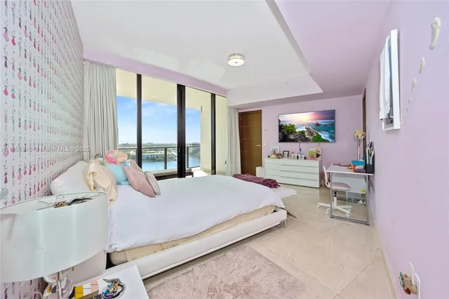 a bedroom with a bed window and a flat tv screen