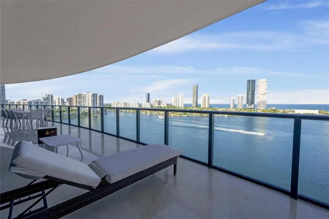 a living room with furniture a kitchen island with sink and cabinets
