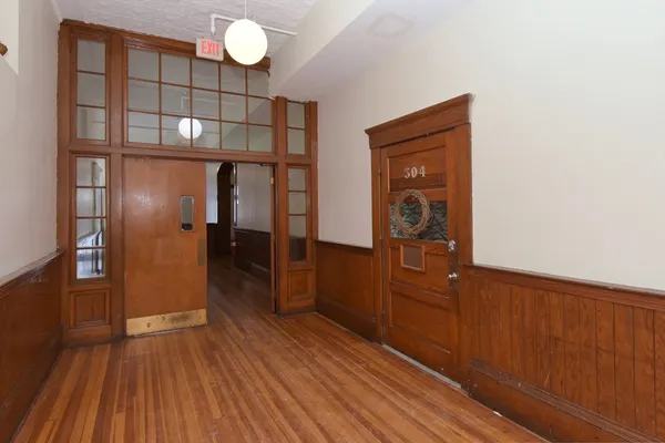 a view of a hallway with wooden floor and staircase