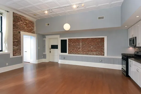 a view of an empty room with a window and fireplace