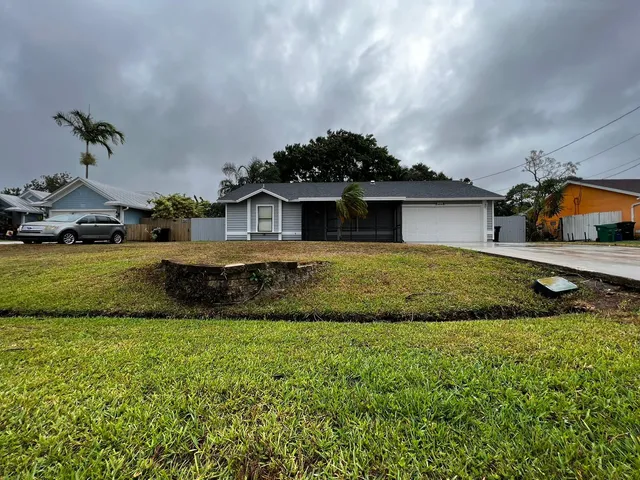 a view of a house with a swimming pool and a yard