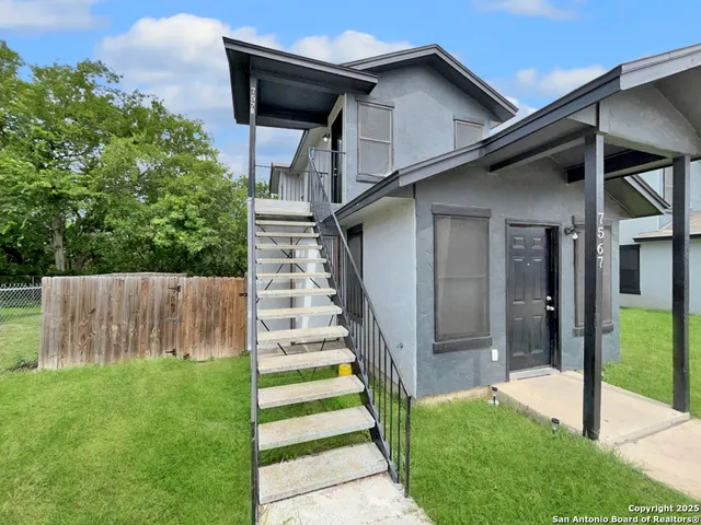 a view of a house with backyard and a garden