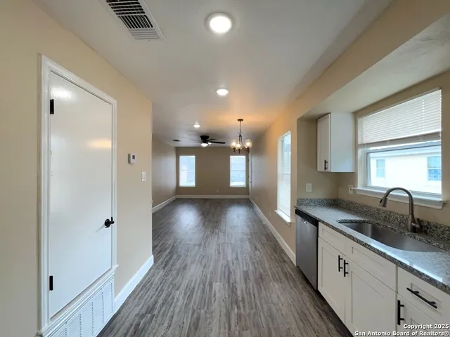 a view of a kitchen with a sink and wooden floor
