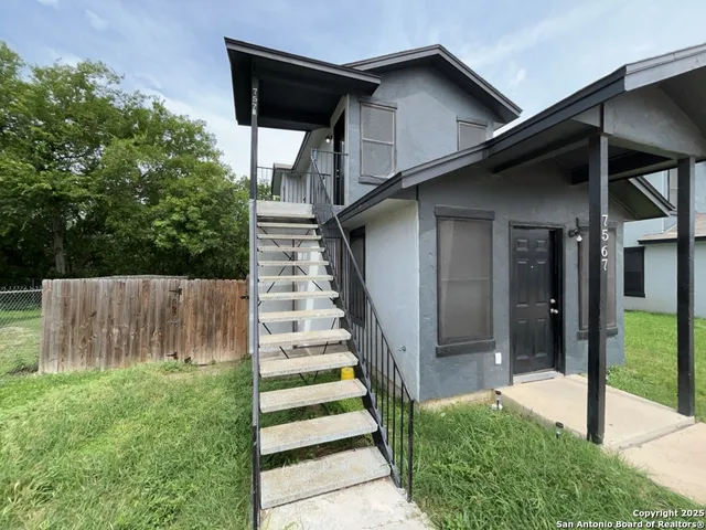 a view of a house with backyard and a garden