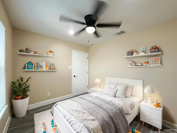 a bedroom with a bed and wooden floor