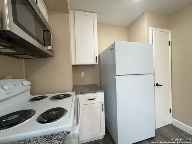 a kitchen with a refrigerator and a stove