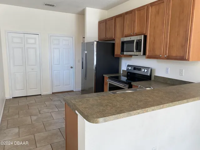 a kitchen with granite countertop a stove a microwave a sink and cabinets