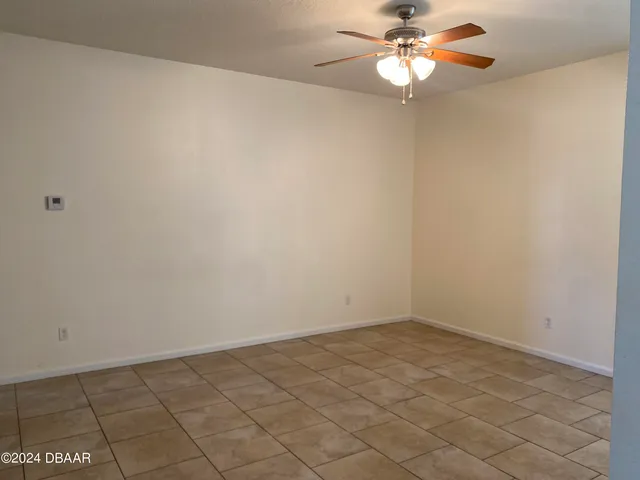 en empty room with ceiling fan and window