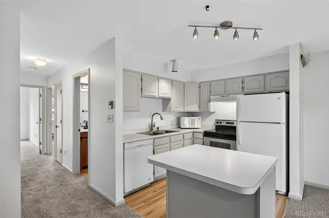 a kitchen with stainless steel appliances a refrigerator sink and white cabinets
