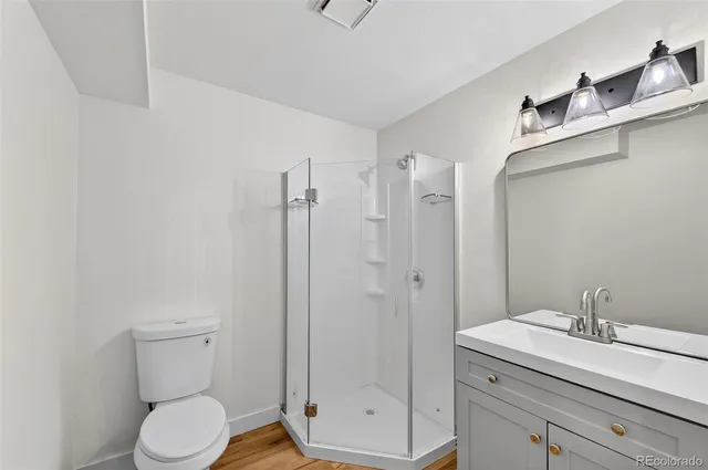 a bathroom with a granite countertop sink toilet and shower