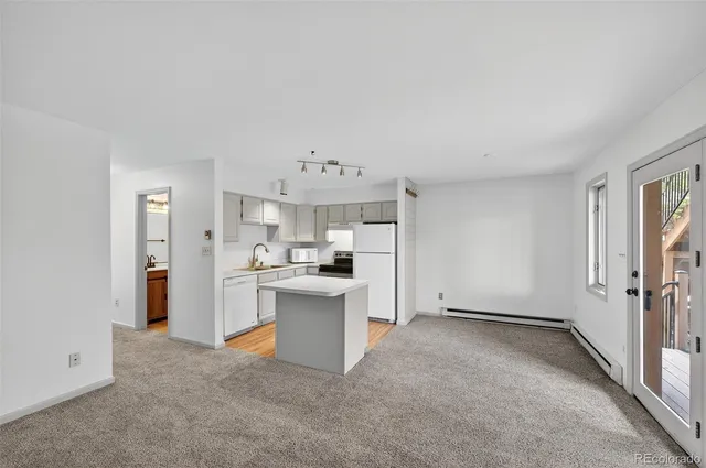 a view of a kitchen with refrigerator sink and cabinets