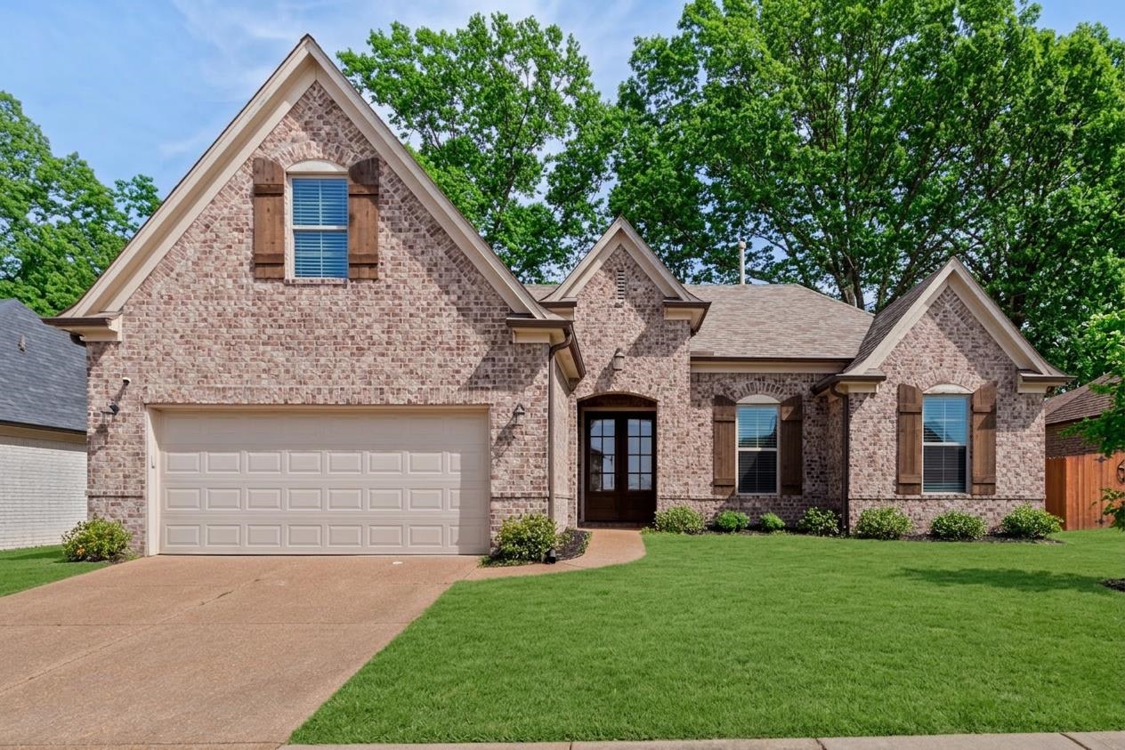 4996 Granite Creek Road Memphis, TN 38125 - Photo 1 of 37 a front view of a house with a yard and garage