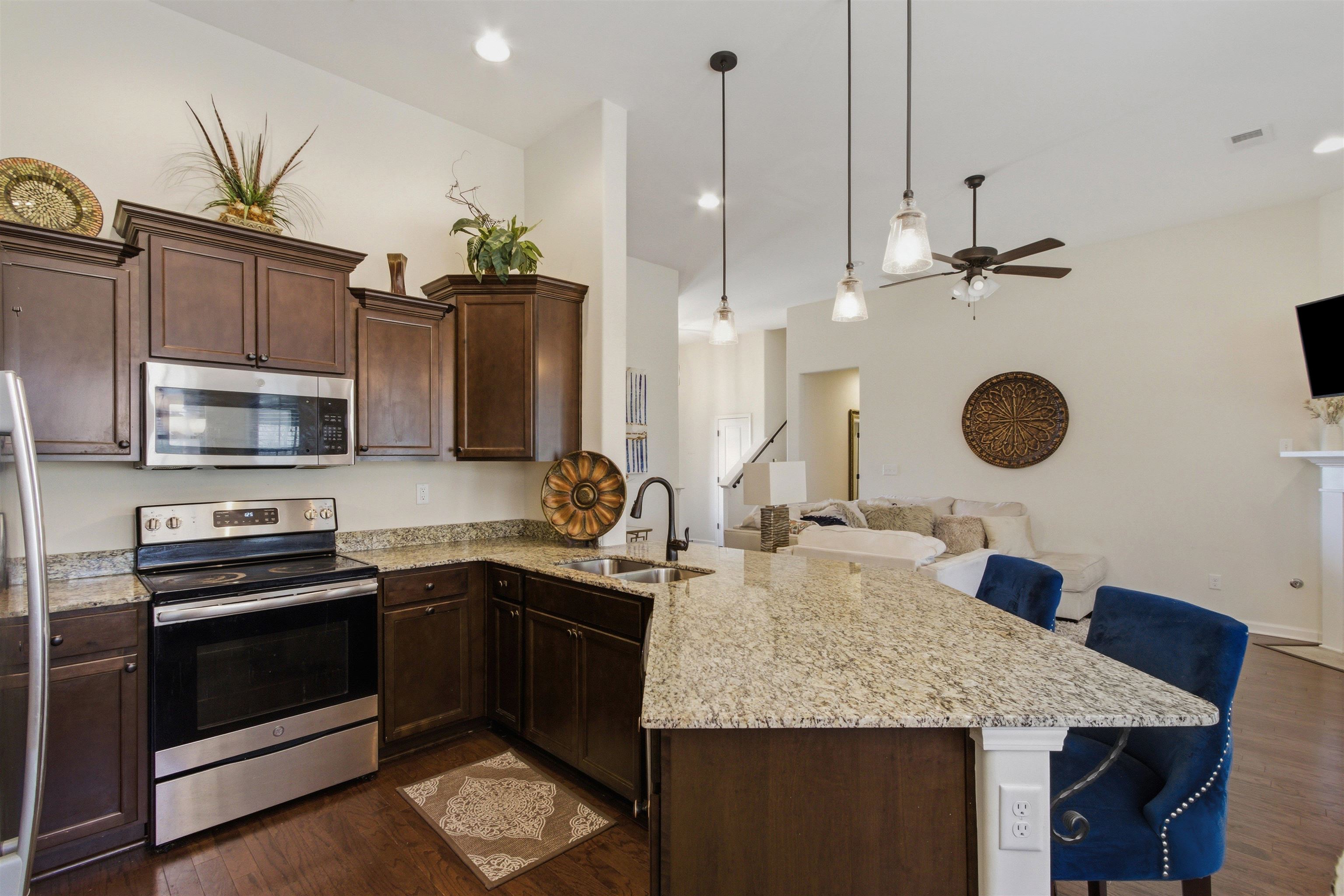 4996 Granite Creek Road Memphis, TN 38125 - Photo 11 of 37 a kitchen with stainless steel appliances granite countertop a sink a stove and a wooden floors