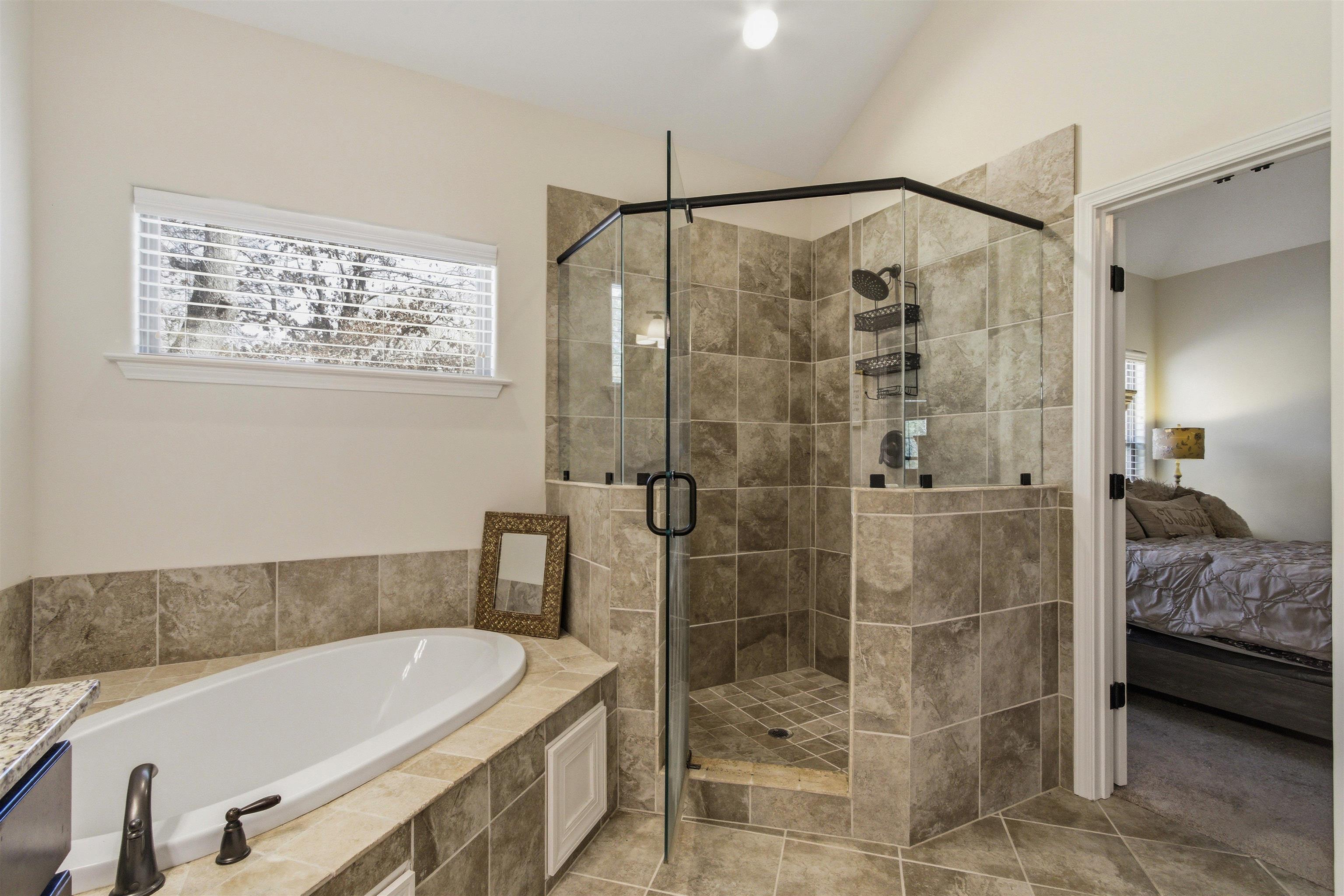 4996 Granite Creek Road Memphis, TN 38125 - Photo 18 of 37 a bathroom with a tub and a shower